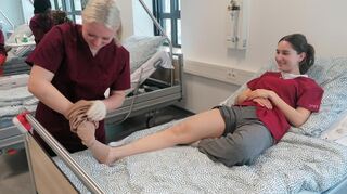 Wichtige Vorbereitung auf den Alltag: Lisa Piskula (links) übt bei Lena Bader, einen Kompressionsstrumpf anzulegen.