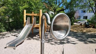 Eine Sprechmuschel des Spielplatztelefons, im Hintergrund das Klettergerüst für die Kleineren
