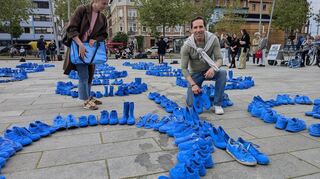 Künstler Frank Schlottmann und eine Teilnehmerin platzieren die letzten Schuhe für die Kunstinstallation.