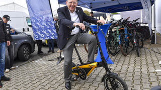 Oberbürgermeister Christian Specht auf einem Falt-Elektrorad einen Tag vor Eröffnung auf dem Maimarkt in Mannheim.