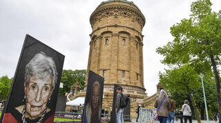 Besucher schauen sich die Porträts vor dem Wasserturm an.