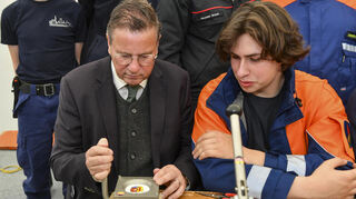 Minister Peter Hauck bei der Jugendfeuerwehr mit Timon Rolke.