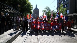 Das Motto der Maikundgebung führt die Demonstration an.