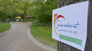 Diese Schilder weisen vom Haupttor aus den Weg zu dem kleinen Pavillon, an dem der Seniorenbeirat seine Kaffeebar aufbaut und Stühle aufstellt.