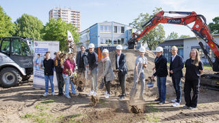 Zupackend präsentieren sich Landrat Christian Engelhardt (5.v.r.), Planer, Verwaltungsmitarbeiter und Schüler beim Spatenstich für das neue Unterrichtsgebäude auf dem südlichen Areal der Friedrich-Fröbel-Schule.