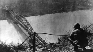 Ein amerikanischer Soldat blickt im Zweiten Weltkrieg auf die Brücke von Remagen (undatiertes Archivfoto).