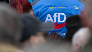 Bei einer Veranstaltung der AfD steht ein Mann mit dem Logo der Partei vor dem Eingang. Nach dem Gutachten des Bundesverfassungssschutzes gibt es wieder eine Debatte über einen Verbotsantrag.