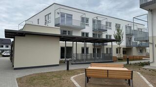 Grünes Wohnquartier im Baugebiet "Mitten im Feld II", links der Aufzug zur Tiefgarage.