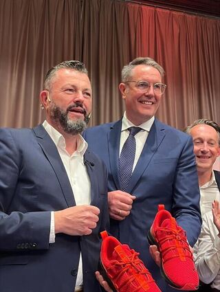 SPD-Ministerpräsident Alexander Schweitzer (rechts) und Jens Peter Gotter halten Laufschuhe in die Kamera, nachdem Gotter zum OB-Kandidat gewählt worden ist.
