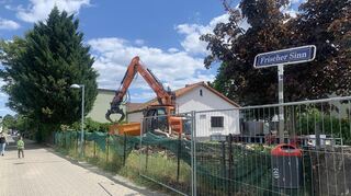 Ein Arbeiter sitzt am Montagmittag auf dem Dach von Dagmars Haus und wirft Ziegel hinunter in den Container. An diesem Dienstagmorgen soll der Abriss beginnen.