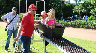 Am Stand der Deutschen Lebens-Rettungs-Gesellschaft (DLRG) rutschten Kinder in Kisten eine Rollenrutsche herunter.