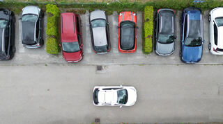 Ein Scan-Auto fährt bei einem Pilotversuch an vor der Universität Hohenheim geparkten Fahrzeugen vorbei (Aufnahme mit Drohne). Als erstes Bundesland ermöglicht Baden-Württemberg es Städten und Gemeinden, so gegen Parksünder vorzugehen.