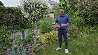 Im Garten seines Hauses in Hofheim kann Bürgermeister-Kandidat Alexander Scholl abschalten – am besten beim Rasenmähen.