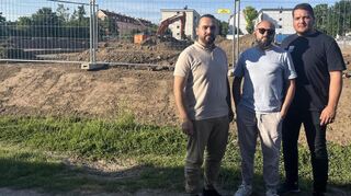 Wollen das Bauvorhaben am liebsten stoppen: Samed Akyüz, Fatih Alkan und Saban Kaya (v.l.) am Bauzaun. Im Hintergrund ihre Wohnhäuser am Riestenweg.