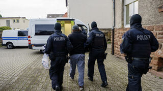Polizisten führen im Mannheimer Stadtteil Waldhof nach einer Razzia im September 2024 einen Mann ab.