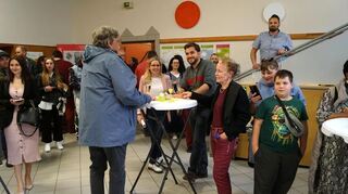 Zahlreiche Gäste bei der Feier zum 15-jährigen Bestehen vom Quartiersbüro Wohlgelegen, auf der Treppe Benjamin Klingler und am Stehtisch in der Mitte Stefanie Paul.