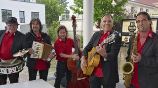 „Singing In The Rain“: Die Musiker-Initiative Lampertheim verbreitet auch bei Regen gute Laune auf dem Marktplatz.