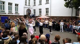 Das Lehrerkollegium tanzt zu Beginn des Schulfestes.