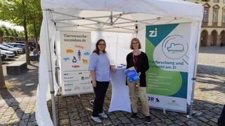 Anne Mallien (ZI-Tierlabor) und Jana Wilken (Initiative "Tierversuche verstehen") an ihrem Stand vor dem Schloss.