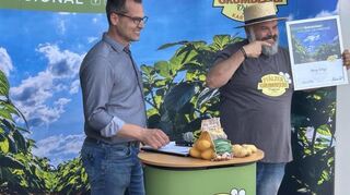 Hartmut Magin überreicht Monji El Bejin seine Ernennungsurkunde zum Markenbotschafter der Pfälzer Grumbeere.