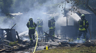 Einsatzkräfte bekämpfen am Donnerstag die Flammen im Sandtorfer Weg, nahe der Bahnlinie.