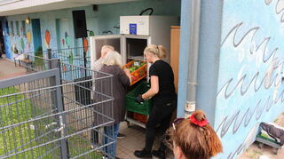 Ehrenamtliche Helfer vom Verein „Food Sharing“ räumen den Lebensmittelschrank auf dem Waldhof ein.