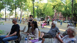 Zuhörende Besucher in der sommerlich heißen Lutherstraße.