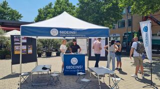Keya Baier und Tabea Simon (v.l.) unter dem Zelt des Kinder- und Jugendbüros, daneben die Tafel mit der Umfrage, an der Kinder und Jugendliche teilnehmen konnten.