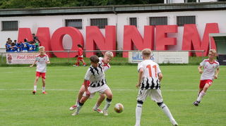 Eine Szene aus dem U12-Spiel des FC Basel gegen Jahn Regensburg – im Hintergrund prangt der MONNEM-Schriftzug von der Buga.