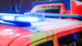 Blaulichter leuchten an einer Einsatzstelle auf einem Notarzt Fahrzeug und einem Rettungswagen.