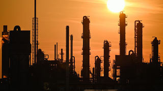 Die Sonne geht hinter Industrieanlagen auf dem Gelände des Chemieunternehmens BASF unter. Auch in Ludwigshafen sieht man die Mainzer Pläne kritisch.