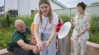 Stadtgärtner Jürgen Rückert, Klimamanagerin Michelle Ohl und Bürgermeisterin Bärbel Schader (rechts) testen das Wasser aus dem neuen Trinkbrunnen vorm Friedhof.