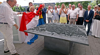 OB Christian Specht, Helen Heberer und Stefan Lochbühler (v. l.). ziehen die Stadtfahne vom Bronzemodell, das nun am Plankenkopf in P 7 steht.