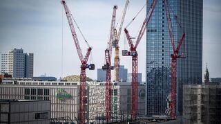 Kräne stehen auf einer Baustelle am Berliner Alexanderplatz. Die Baufirmen hoffen, dass sie von dem Sondervermögen für die Infrastruktur profitieren.