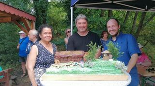 Clarissa Bravo (links) hat den Abenteuerspielplatz als Kuchen gebacken. Daneben: Michael Nied (Bezirksleiter) und Manuel D‘Auria (Leiter Abenteuerspielplatz).