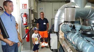 Blick hinter die Kulissen: Uwe Merz (rechts) stellt bei seiner Führung auch den Notstromdiesel für Bauhof, Kläranlage und Feuerwehr vor. Fünf seiner Mitarbeiter sind auch ausgebildete Feuerwehrleute, die beim Einsatz vor Ort die Feuerwehr unterstützen.