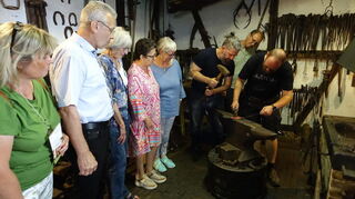 Die Schmiede Sven Seitz und Jan Müller in Aktion, links Bürgermeister Gottfried Störmer und Ehefrau Sabine und Museumsgeister.