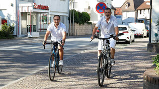 Steffen Platz (l.) und Harald Seibert radelten ausnahmsweise für das Foto auf dem Bürgersteig vor dem Rathaus. Seibert fährt überall mit dem Rad hin, Platz nutzt es für den Weg zur Arbeit nach Ludwigshafen.