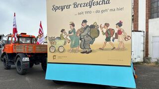 Dieser Wagen war einst in der Mainzer Fasnacht unterwegs und kommt nun in Speyer zum Einsatz. Gestaltet wurde er mit Originalentwürfen aus dem Jahr 1951 von Friedrich Josse. Er fasst bis zu 14 Personen - und viele Brezeln.
