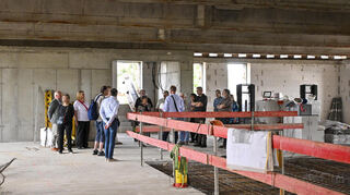 Hier zieht die Schulleitung ein. Architekt Franck erläutert Besuchern die Bauarbeiten im obersten Stockwerk.
