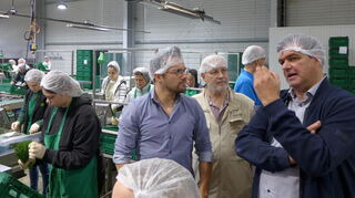 Stefan Böttcher (v.r.) erklärt Dr. Gerhard Weitz und Levin Held die Abläufe bei der Verpackung der Schnittkräuter.