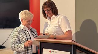 Adelheid Schultheiß (l.) erhält von Jutta Hoffmann vom hessischen DRK die goldene Ehrennadel.