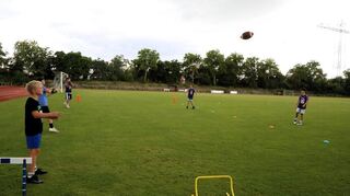 Das Werfen und Fangen des Footballs muss eingeübt werden.