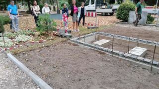 Bereichsleiterin Gabriele Bindert (2.v.r.) zeigt die Flächen für die neuen Kräuterrasengräber auf dem Hauptfriedhof.