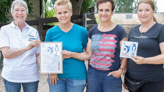 Gabriela Petraß (l.) vom Lampertheimer Nabu übergibt die Plakette für ein „Schwalbenfreundliches Haus“ auf der Reitanlage Zum Schießhof. Neben ihr stehen Anja Christmann, Meike Christmann und Tamara Gertel.
