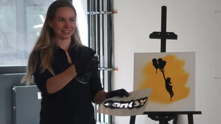 Kuratorin Virginia Jean demonstriert den Einsatz von Banksy-typischen Schablonen.