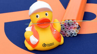 So dünn ist eine Glasfaser: Die Ente hat einen Dreierstrang im Schnabel, rechts daneben ein Bündel von Leerrohren, die im Tiefbau eingesetzt werden. De Faser wird erst zum Schluss eingeblasen.