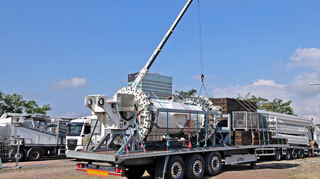Die Sattelschlepper stehen auf dem Sandplatz und werden ausgerichtet. Materialcontainer werden positioniert.