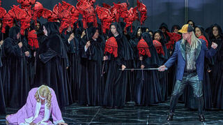 Catherine Foster (Brünnhilde, l), Michael Kupfer-Radecky (Gunther) und der Chor der Bayreuther Festspiele im 2. Aufzug der „Götterdämmerung“ von Richard Wagner auf der Bühne.