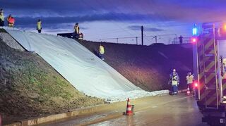 Ilvesheim/Neckarhausen, 1.8.2025: Durch starke Regenfälle sind Teile eines Hangs an der neuen L 597 auf einen Weg und die Straße gerutscht, Feuerehr Ilevsheim und Technisches Hilfswerk sicherten den Hang mit Planen ab.